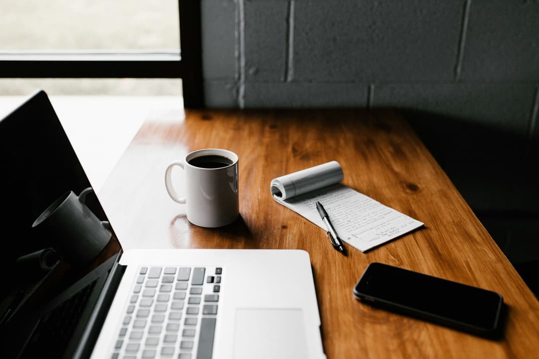 Professional workspace with laptop, coffee, and planning materials - streamlined no ratio loan process for real estate investors in Columbus Ohio